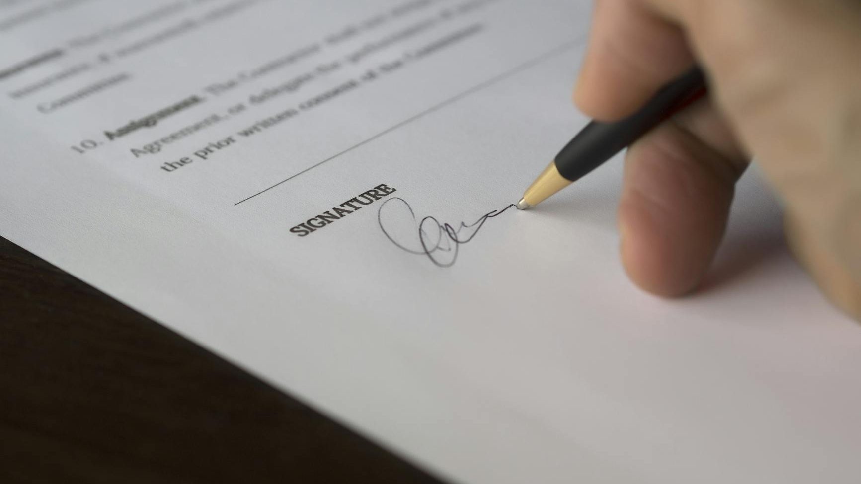 A legal business document being signed
